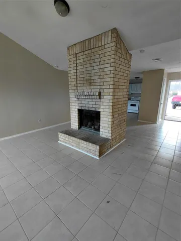 an empty room with windows and fireplace