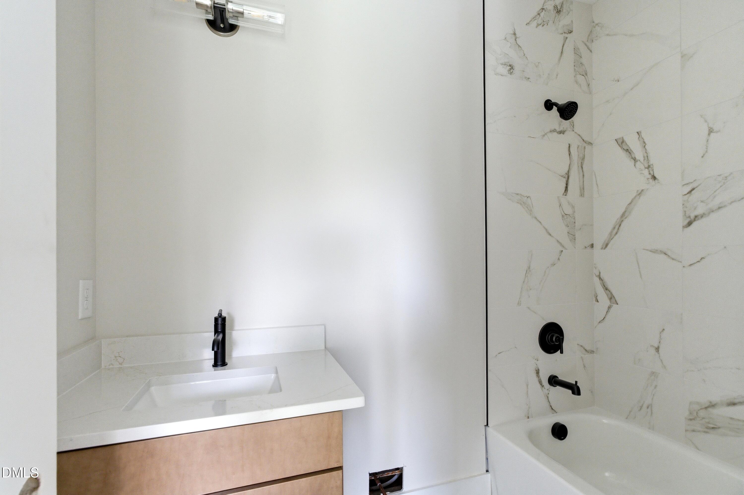 720 Noble Town Way, Unit 105 Raleigh, NC 27603 - Photo 15 of 23 This secondary bedroom suite features stylish lighting, cabinetry, counters, and shower tile, with a tub option
