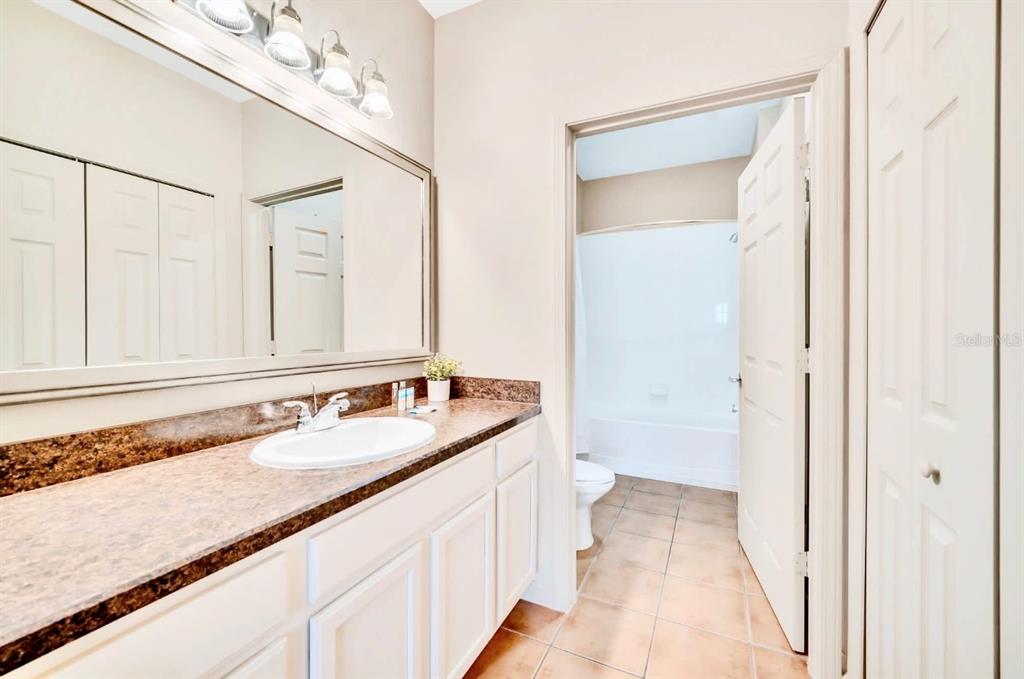 14200 Avalon Road, Unit 426 Winter Garden, FL 34787 - Photo 18 of 44 a bathroom with a granite countertop sink a mirror and a shower