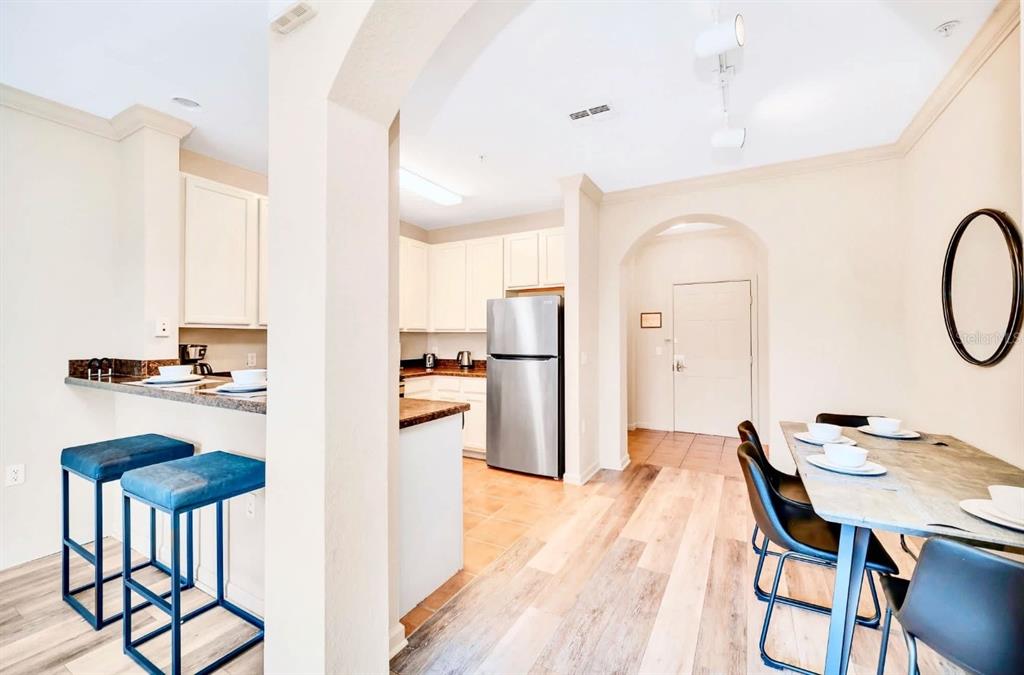 14200 Avalon Road, Unit 426 Winter Garden, FL 34787 - Photo 2 of 44 a kitchen with stainless steel appliances granite countertop a dining table chairs and a refrigerator
