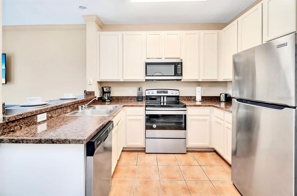 14200 Avalon Road, Unit 426 Winter Garden, FL 34787 - Photo 4 of 44 a kitchen with a sink a stove a microwave and refrigerator