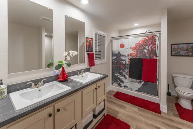 a en suite bathroom with double vanity sink a mirror and a shower