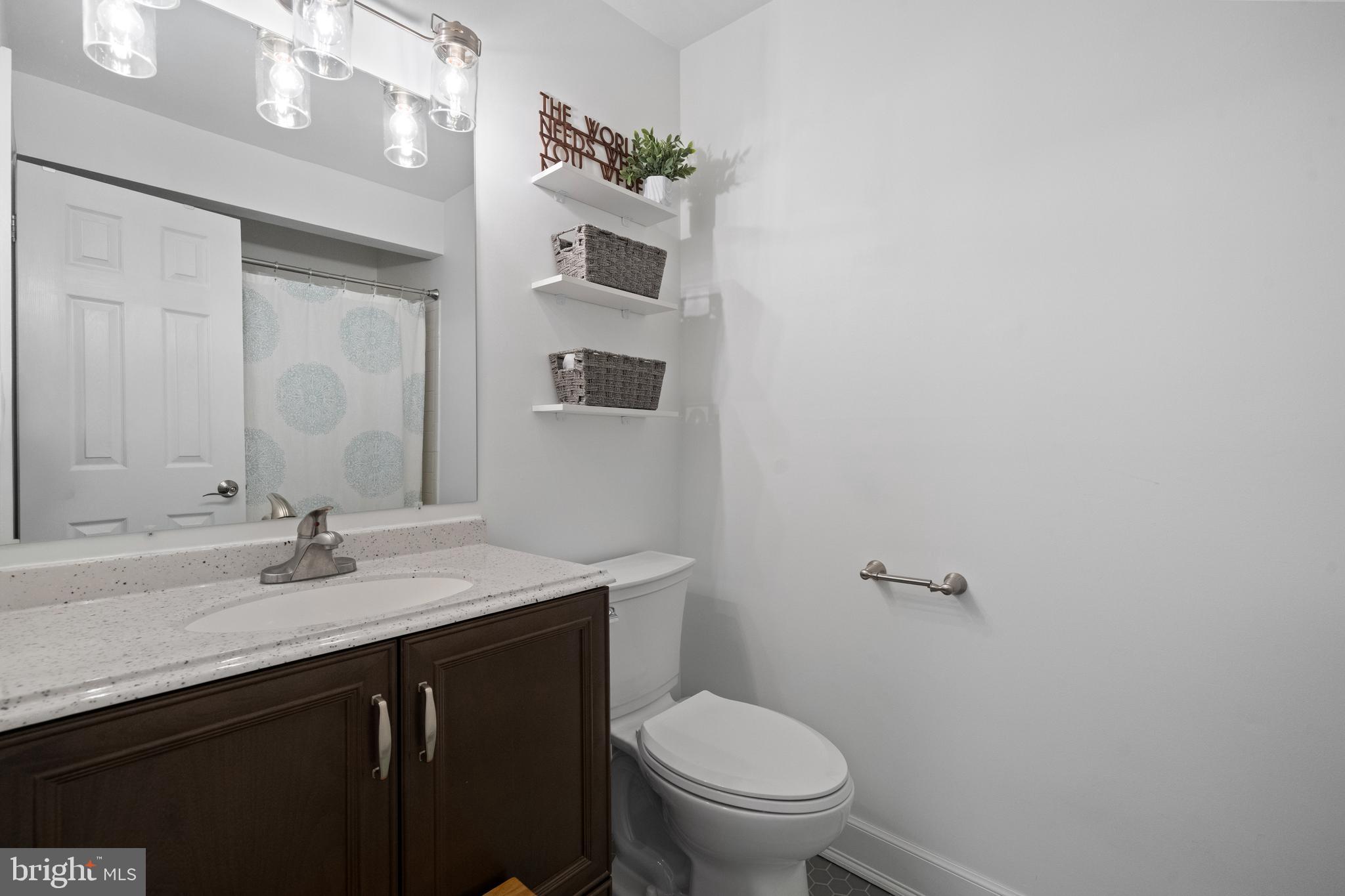 6022 Curtier Drive, Unit E Alexandria, VA 22310 - Photo 18 of 38 a bathroom with a sink a toilet and mirror