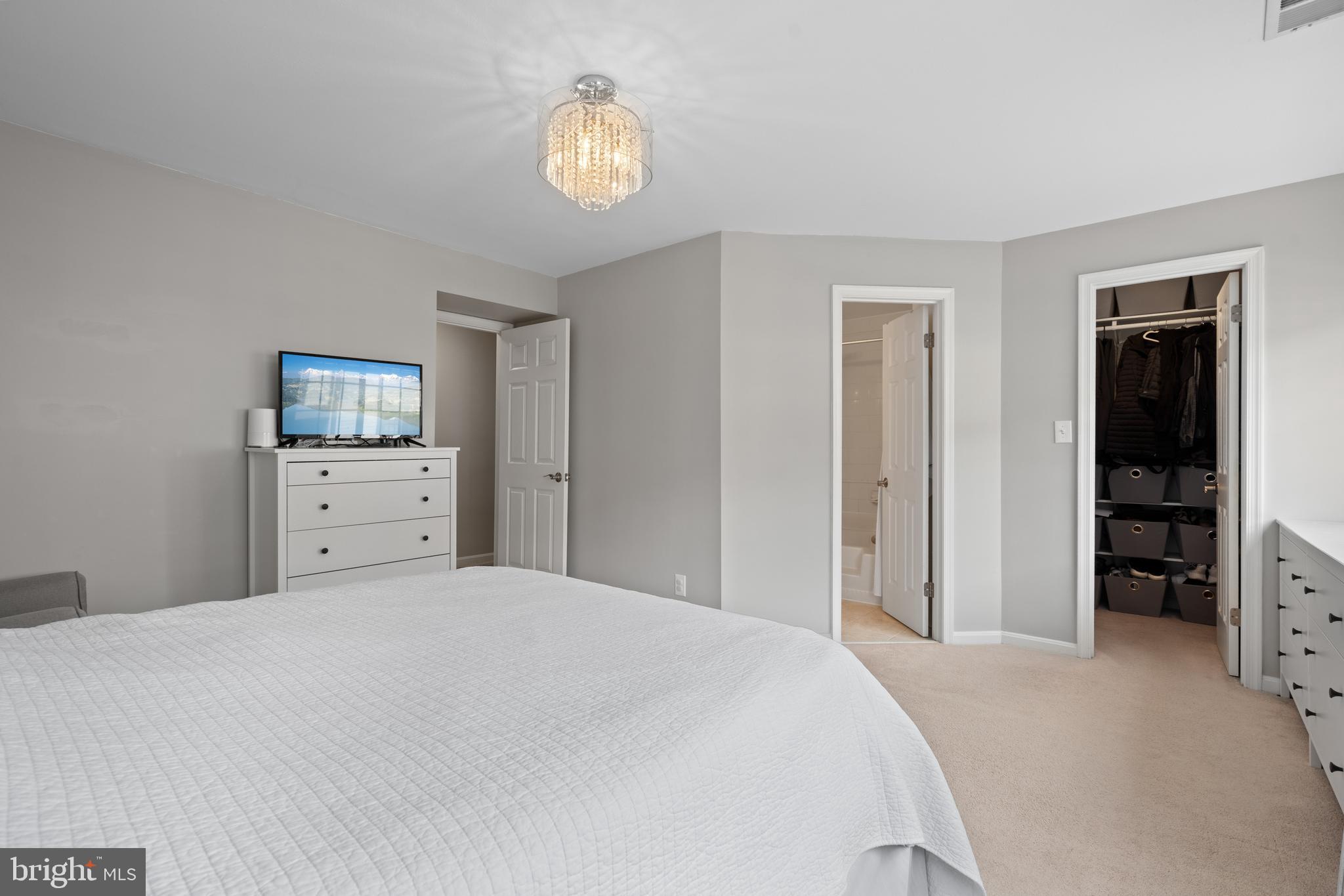 6022 Curtier Drive, Unit E Alexandria, VA 22310 - Photo 25 of 38 a bedroom with a bed and a chandelier