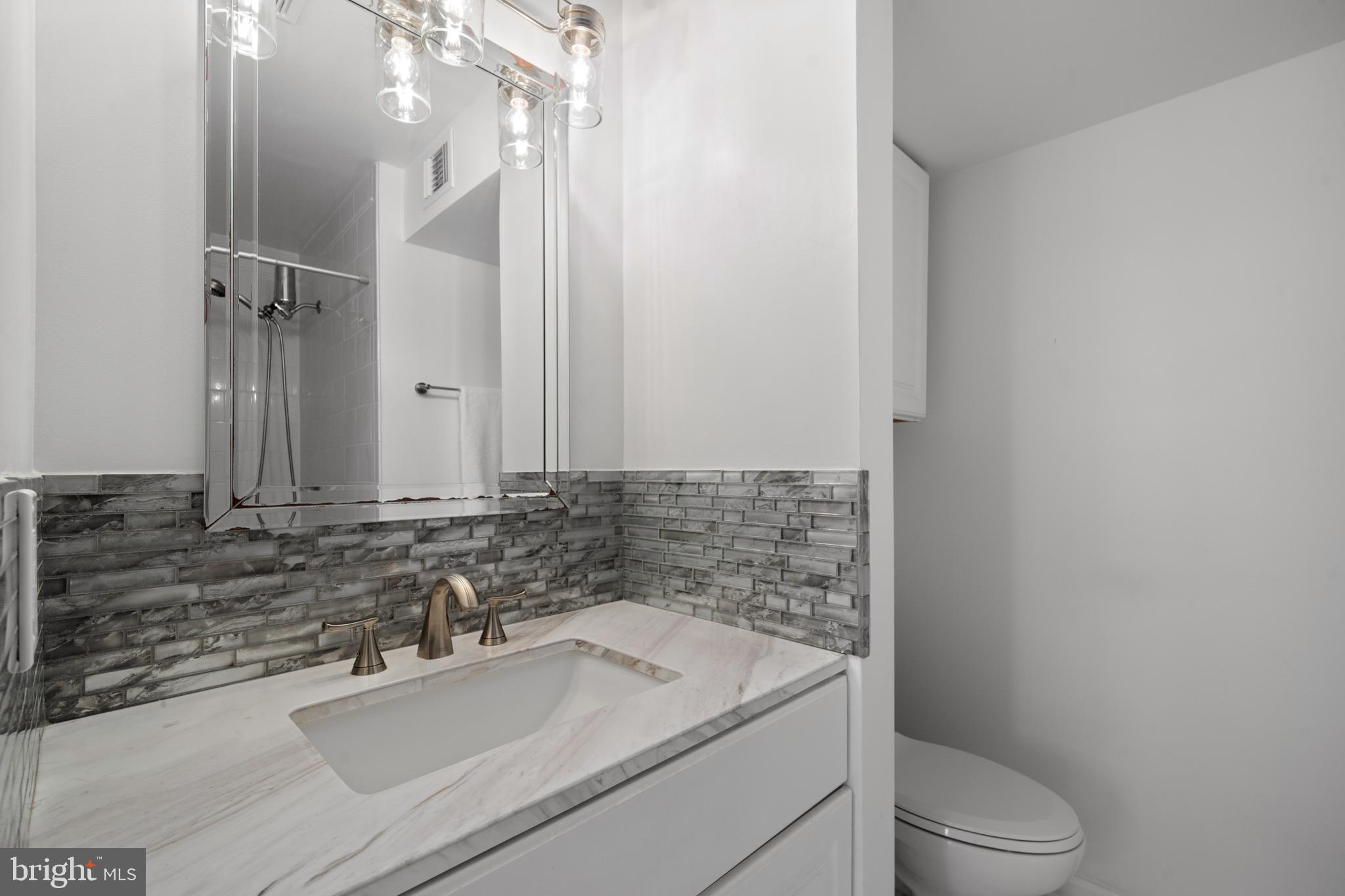 6022 Curtier Drive, Unit E Alexandria, VA 22310 - Photo 27 of 38 a bathroom with a sink toilet vanity and shower