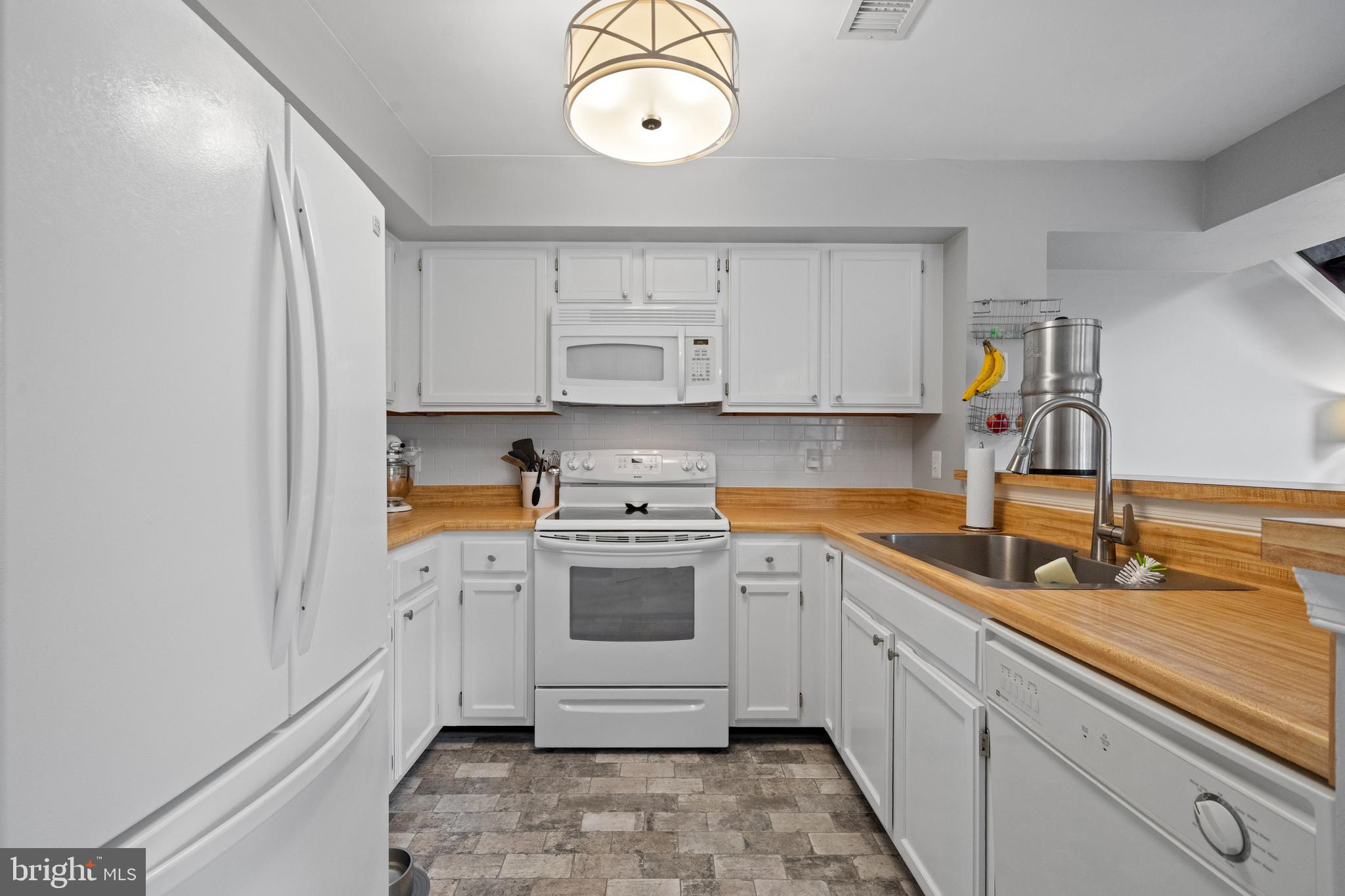 6022 Curtier Drive, Unit E Alexandria, VA 22310 - Photo 5 of 38 a kitchen with a sink cabinets and wooden floor