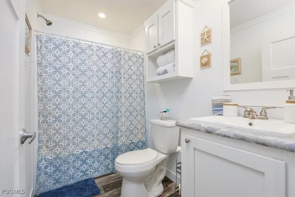 a bathroom with a granite countertop toilet sink and mirror