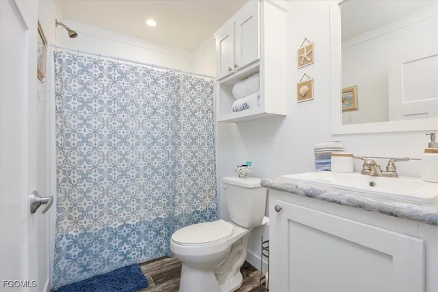 a bathroom with a granite countertop toilet sink and mirror