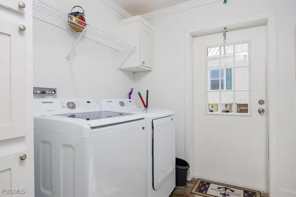 a utility room with cabinets washer and dryer