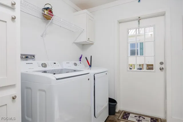 a utility room with cabinets washer and dryer