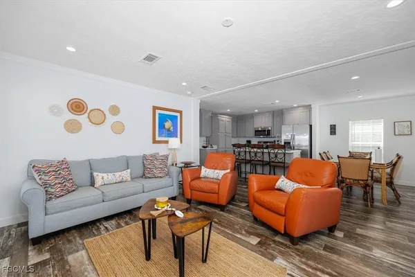 a living room with furniture kitchen view and a potted plant