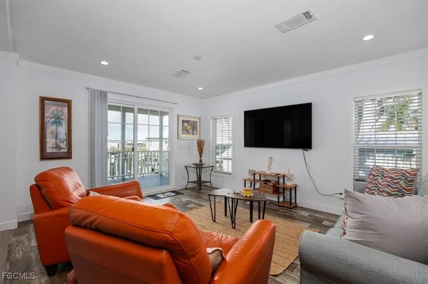 a living room with furniture a flat screen tv and a window