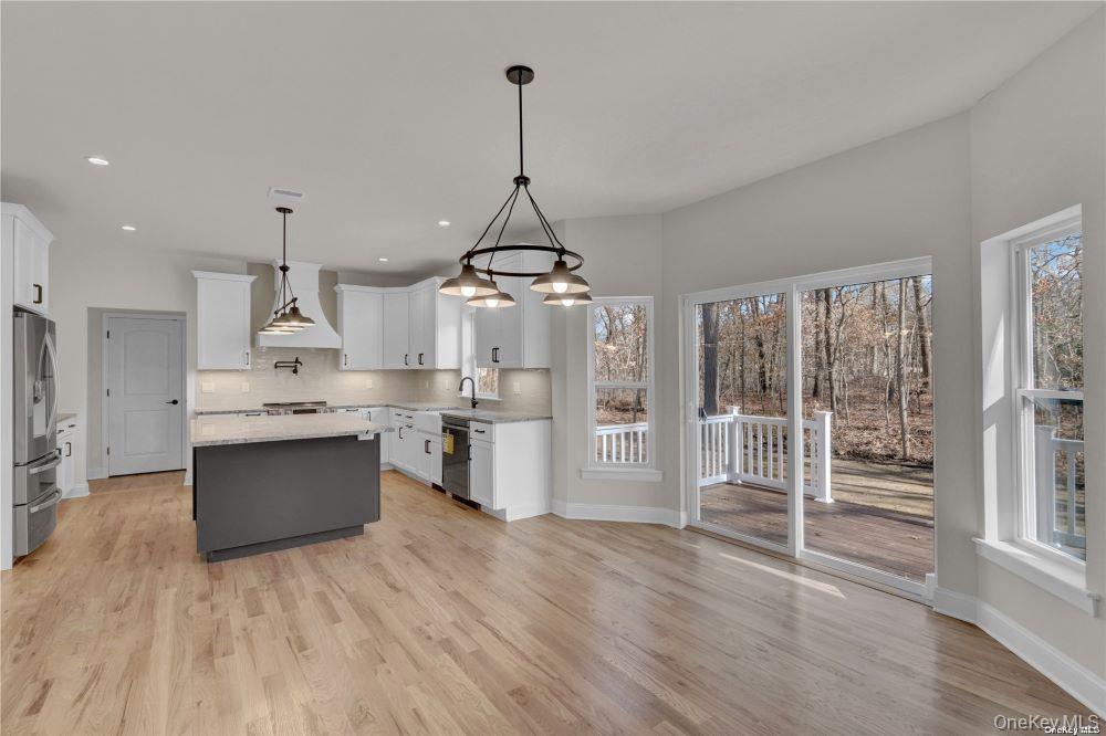 Lot 3 Westfield Road Coram, NY 11727 - Photo 6 of 25 a kitchen with stainless steel appliances granite countertop a refrigerator a sink dishwasher a oven and a dining table with wooden floor