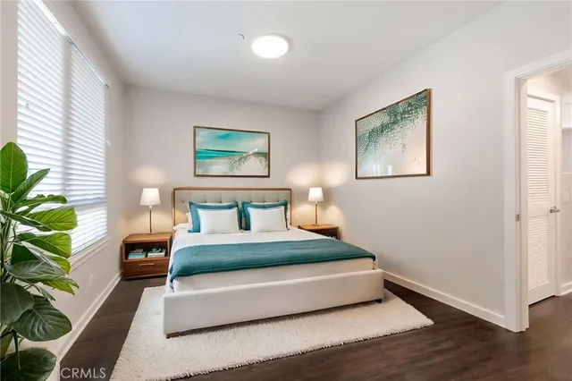 a bedroom with a bed lamp and a potted plant