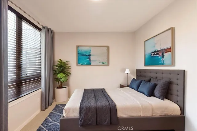 a bedroom with a bed and a painting on the wall