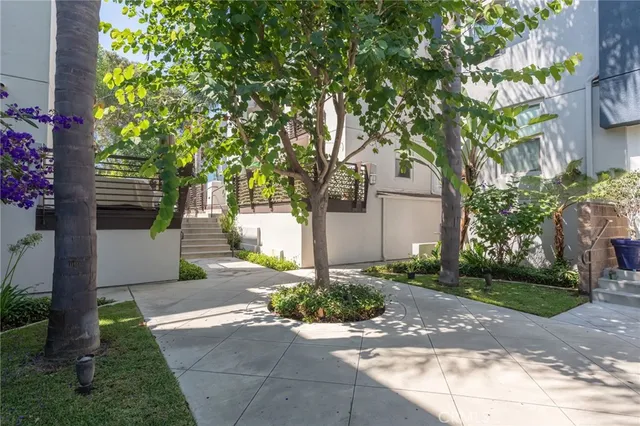 a front view of a house with a yard and tree