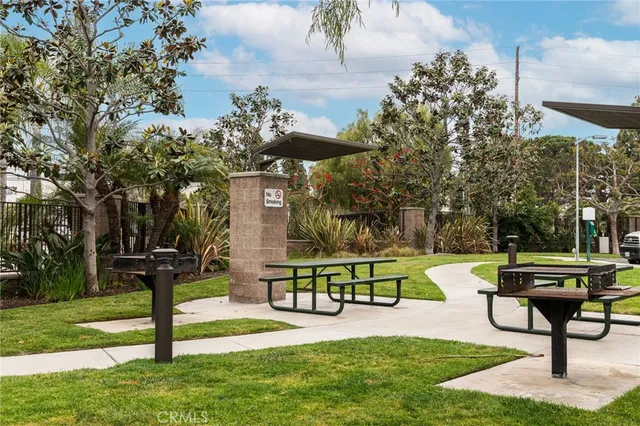 a front view of a house with garden and a bench