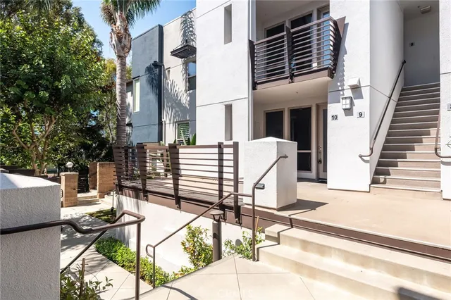 a view of a patio with a table and chairs and couches with wooden floor and fence