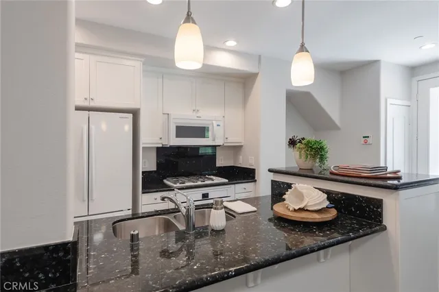 a kitchen with a sink a stove and chairs
