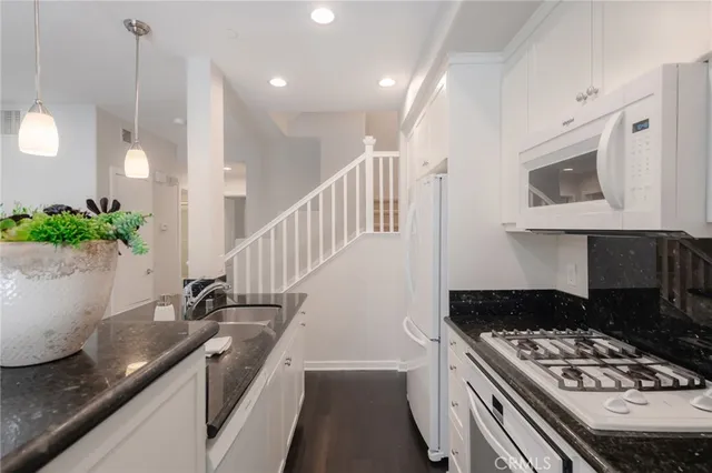 a kitchen with granite countertop a stove and a sink
