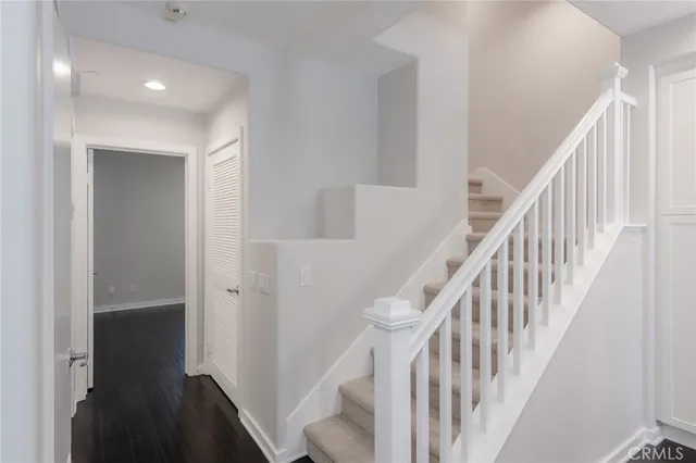 a view of staircase with wooden floor and white walls