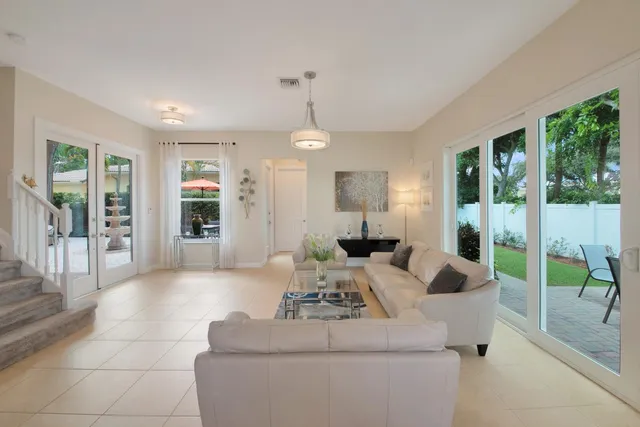 a living room with furniture kitchen view and a chandelier