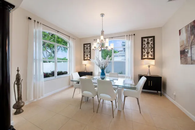 a living room with furniture kitchen area and a large window