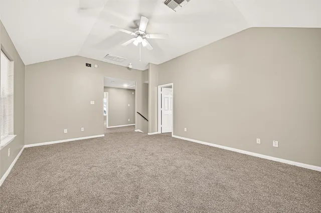 an empty room with a chandelier fan and closet