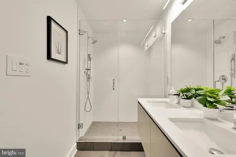 a bathroom with a shower sink and mirror