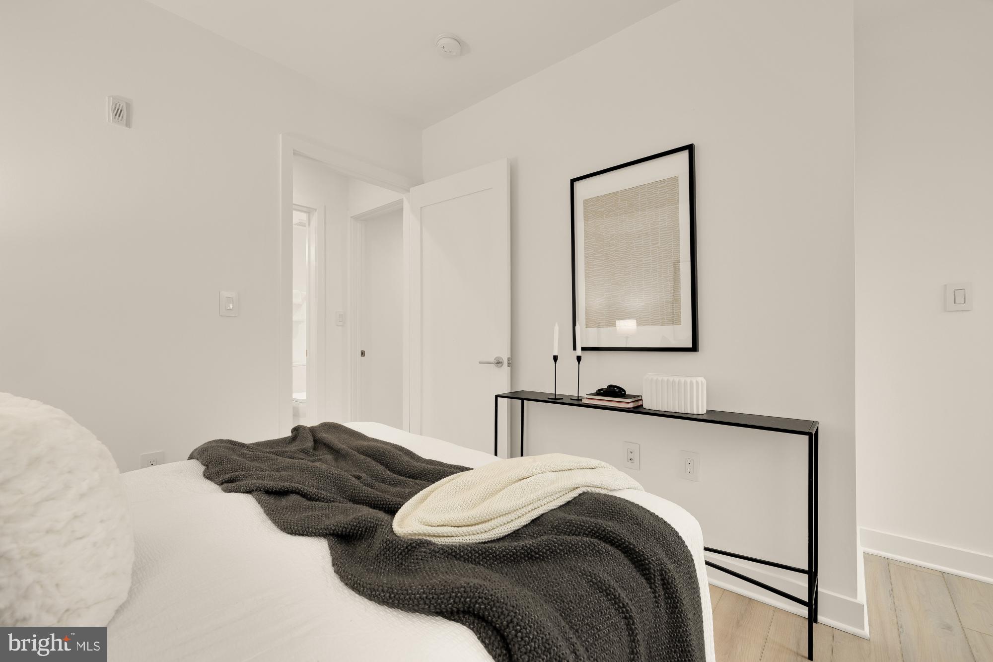 1101 Q Street Northwest, Unit 103 Washington, DC 20001 - Photo 22 of 26 a bedroom with a bed and a mirror