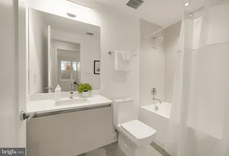 a bathroom with a sink toilet mirror and shower
