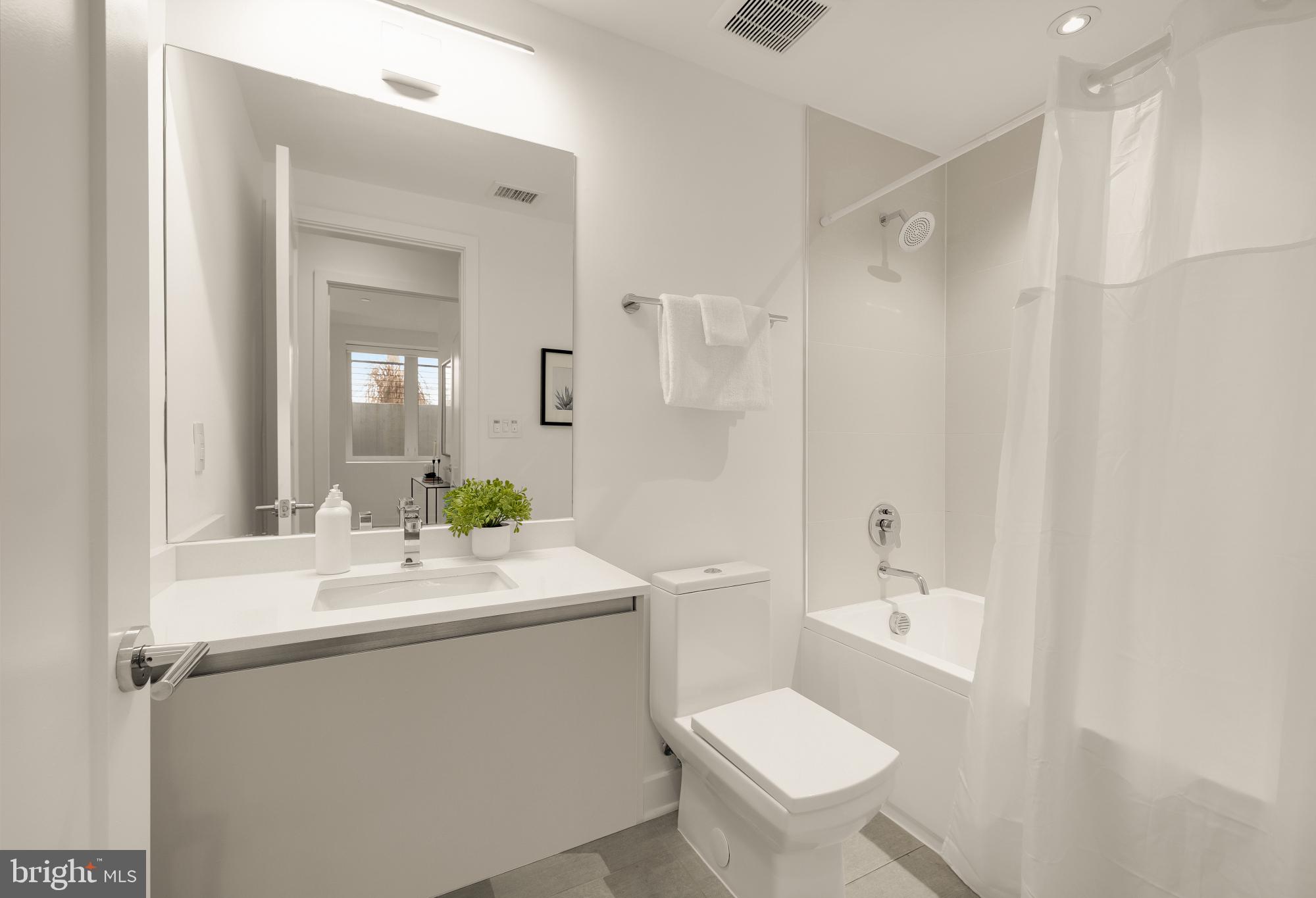 1101 Q Street Northwest, Unit 103 Washington, DC 20001 - Photo 23 of 26 a bathroom with a sink toilet mirror and shower