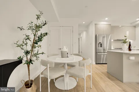 a kitchen with stainless steel appliances kitchen island granite countertop a table and chairs in it
