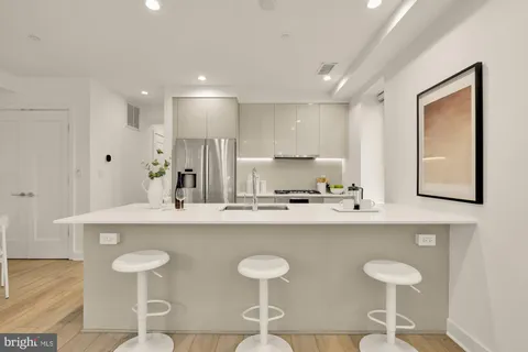 a kitchen with stainless steel appliances a sink and a refrigerator