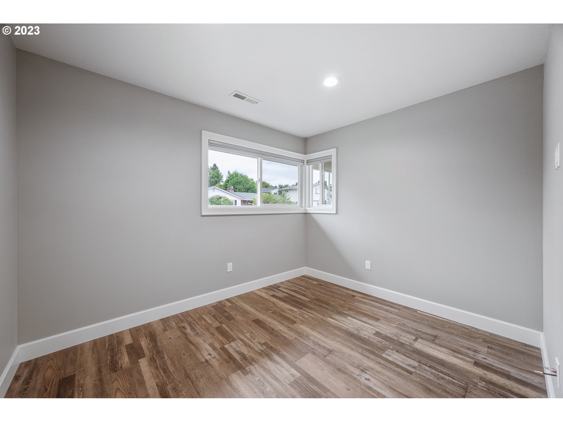 1427 Southeast 109th Avenue Portland, OR 97216 - Photo 19 of 44 a view of an empty room with wooden floor and a window