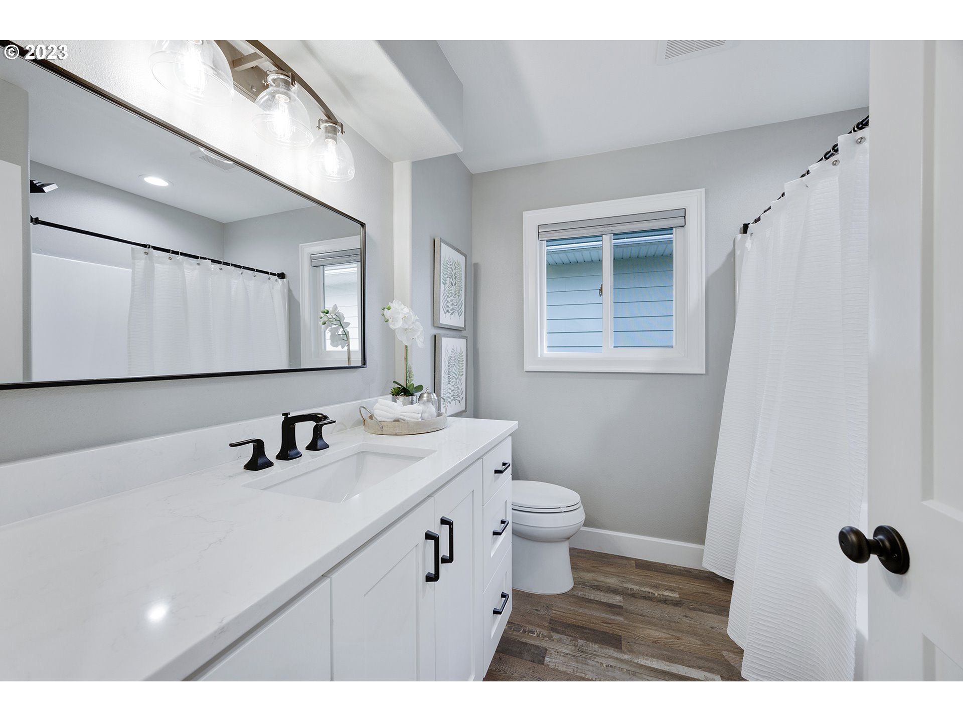 1427 Southeast 109th Avenue Portland, OR 97216 - Photo 21 of 44 a bathroom with a sink a toilet a mirror and vanity