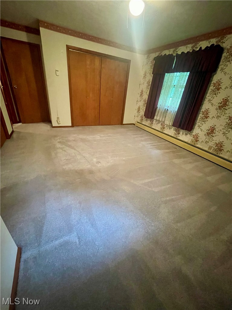 7815 Cemetery Road Vermilion, OH 44089 - Photo 16 of 43 Unfurnished bedroom with ceiling fan, a closet, carpet, and a baseboard radiator
