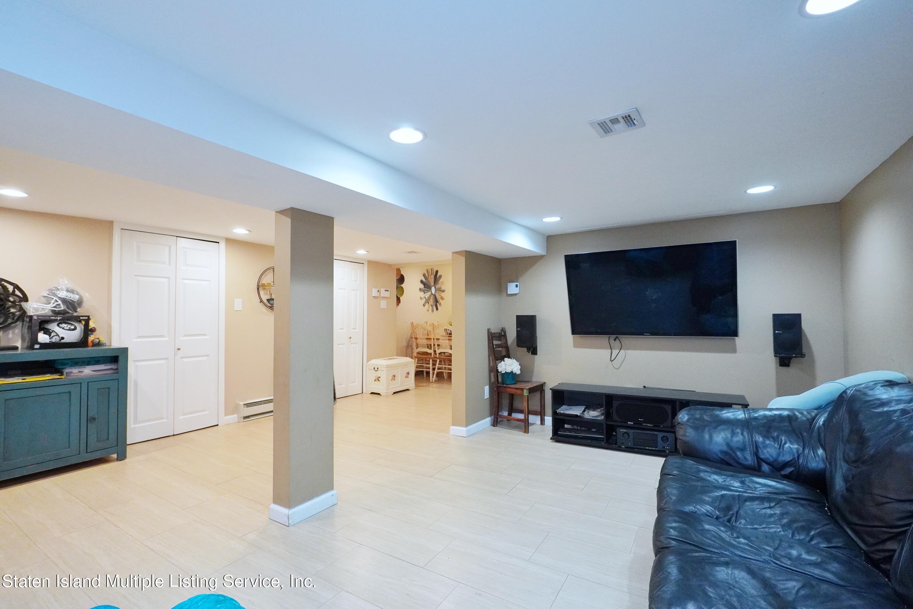 72 Middle Loop Road Staten Island, NY 10308 - Photo 13 of 38 a living room with furniture and a flat screen tv