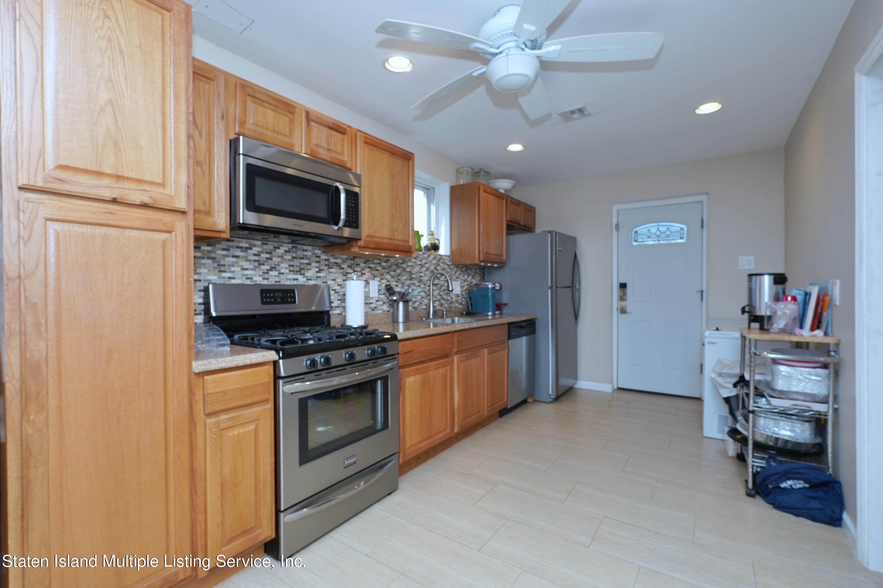 72 Middle Loop Road Staten Island, NY 10308 - Photo 18 of 38 a kitchen with stainless steel appliances granite countertop a stove top oven a sink and a refrigerator