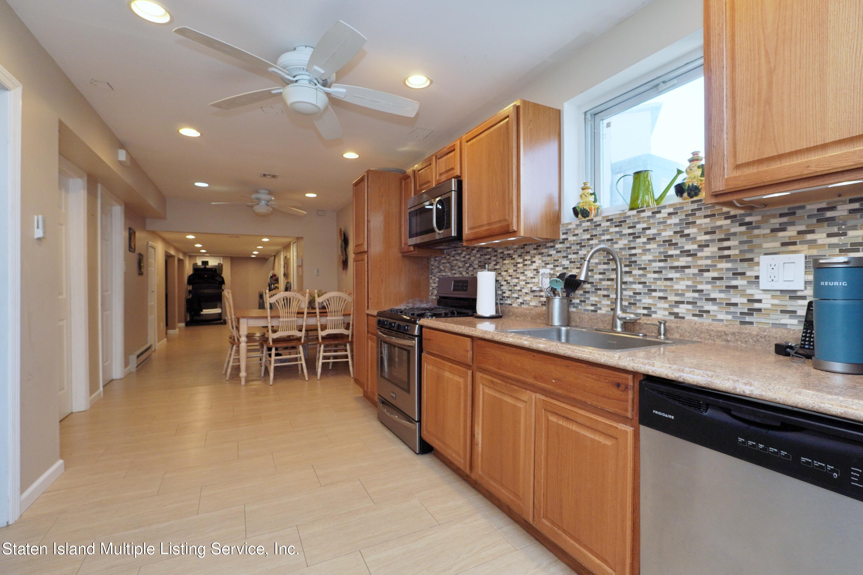 72 Middle Loop Road Staten Island, NY 10308 - Photo 19 of 38 a kitchen with stainless steel appliances kitchen island granite countertop a sink and cabinets