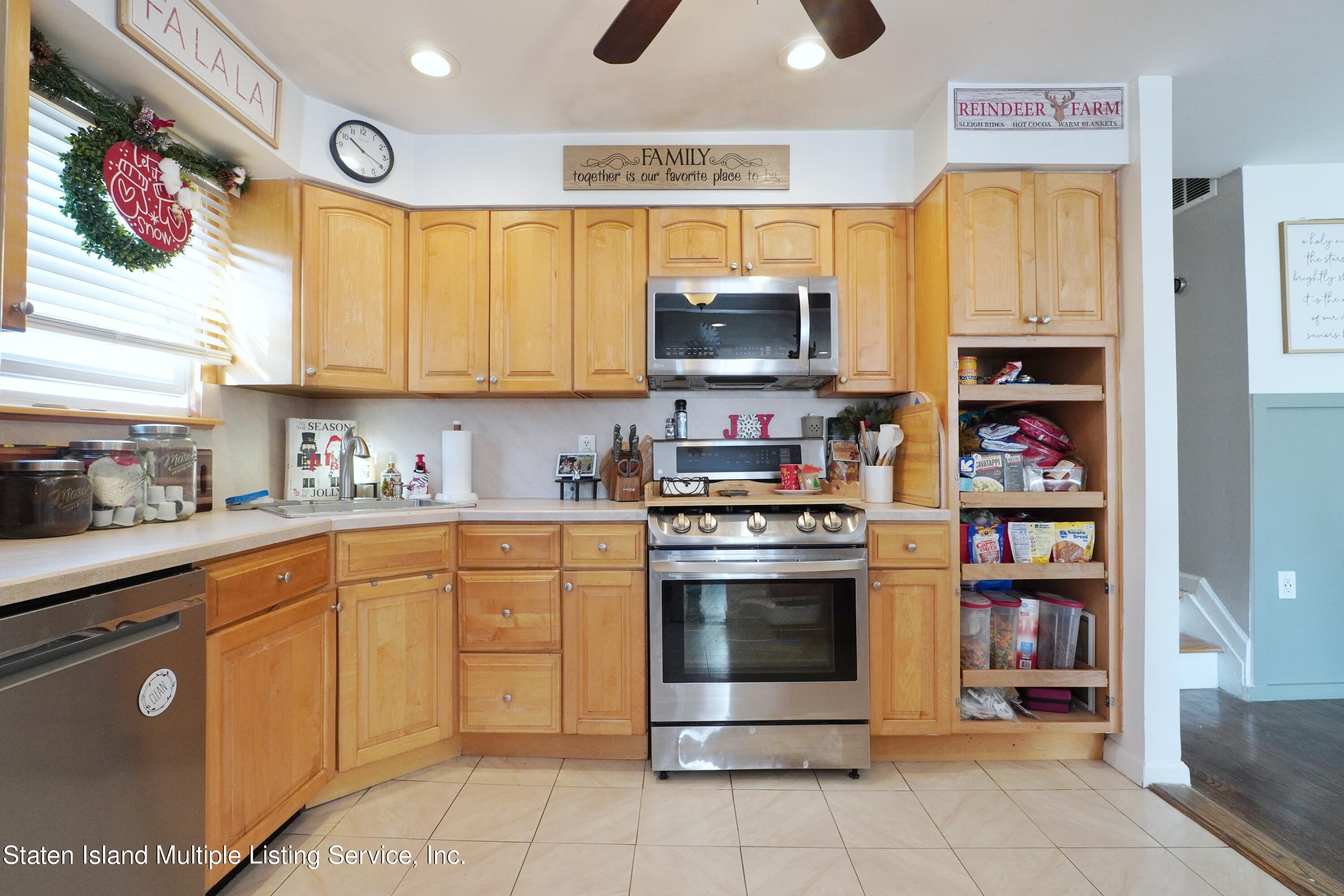 72 Middle Loop Road Staten Island, NY 10308 - Photo 25 of 38 a kitchen with stainless steel appliances granite countertop a stove top oven a sink dishwasher and a refrigerator with wooden cabinets