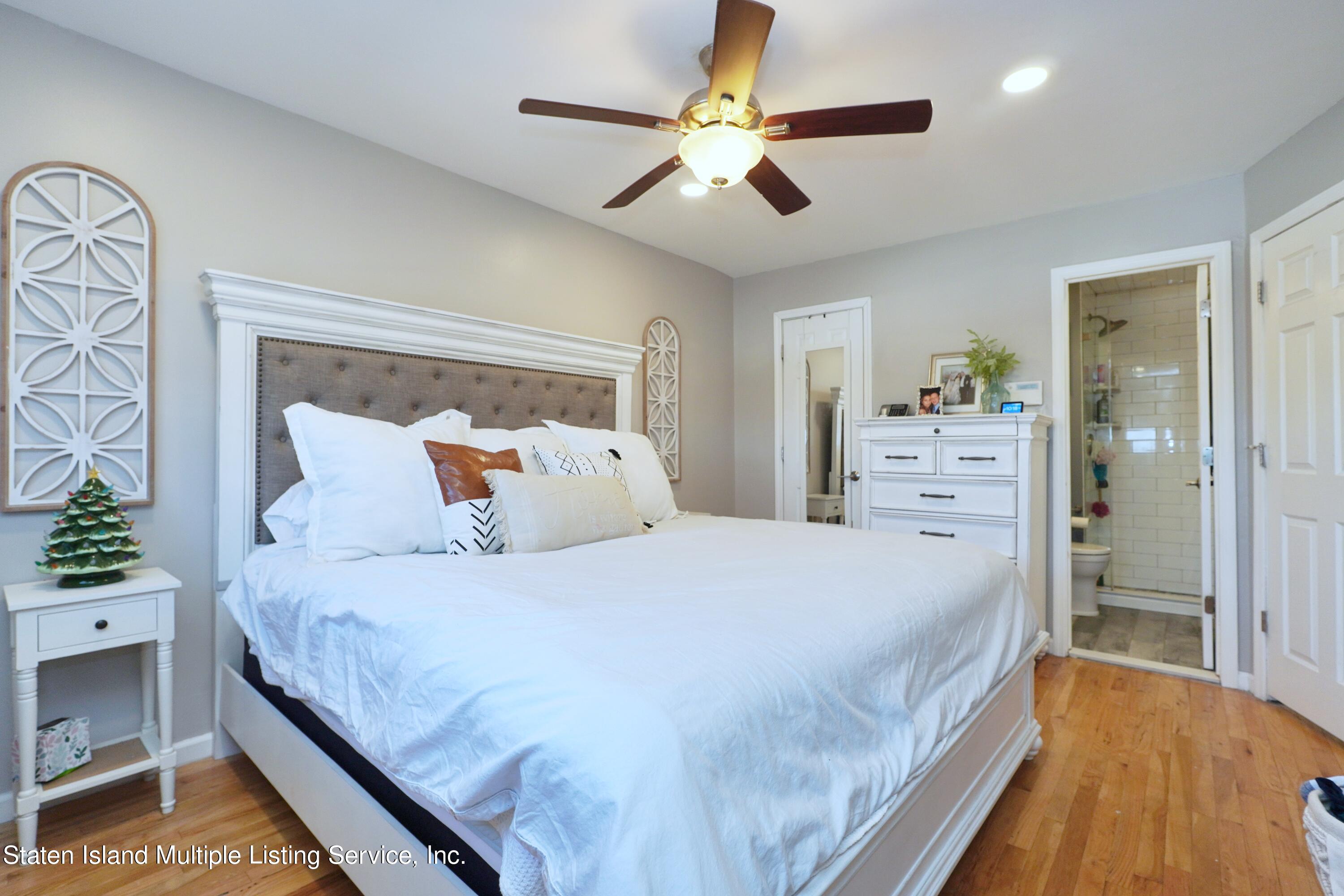 72 Middle Loop Road Staten Island, NY 10308 - Photo 29 of 38 a bedroom with a bed and a chandelier