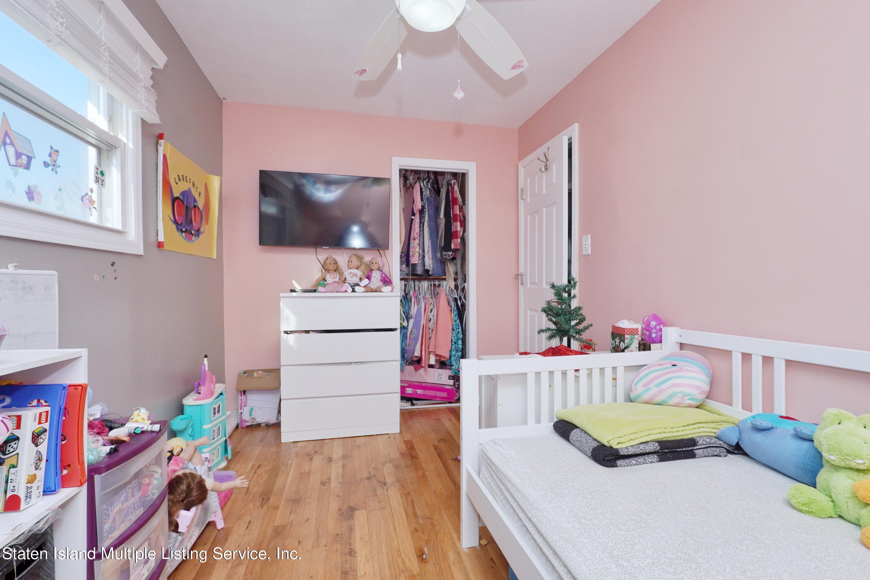 72 Middle Loop Road Staten Island, NY 10308 - Photo 32 of 38 a bedroom with furniture and a baby crib