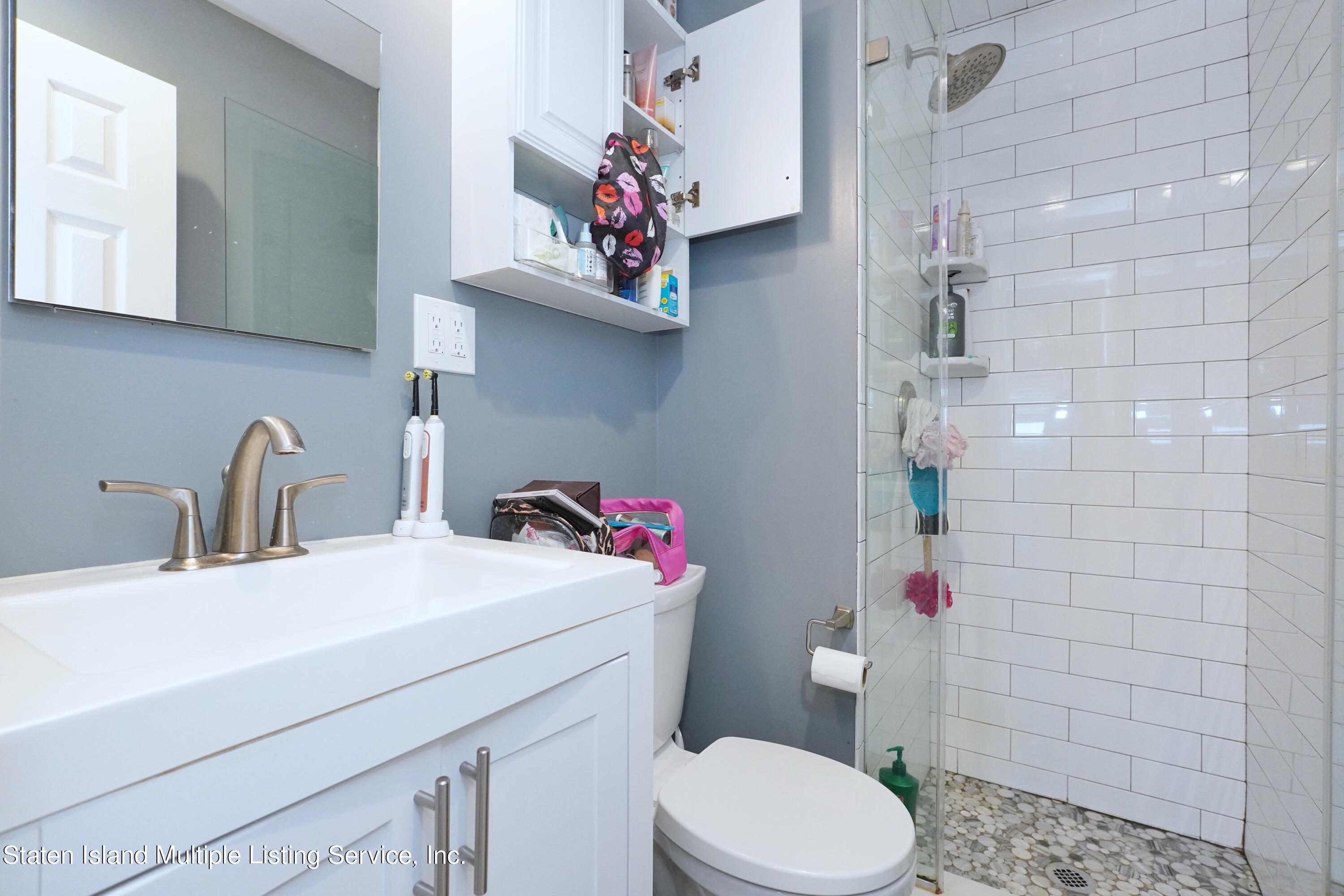 72 Middle Loop Road Staten Island, NY 10308 - Photo 33 of 38 a bathroom with a sink mirror vanity and toilet