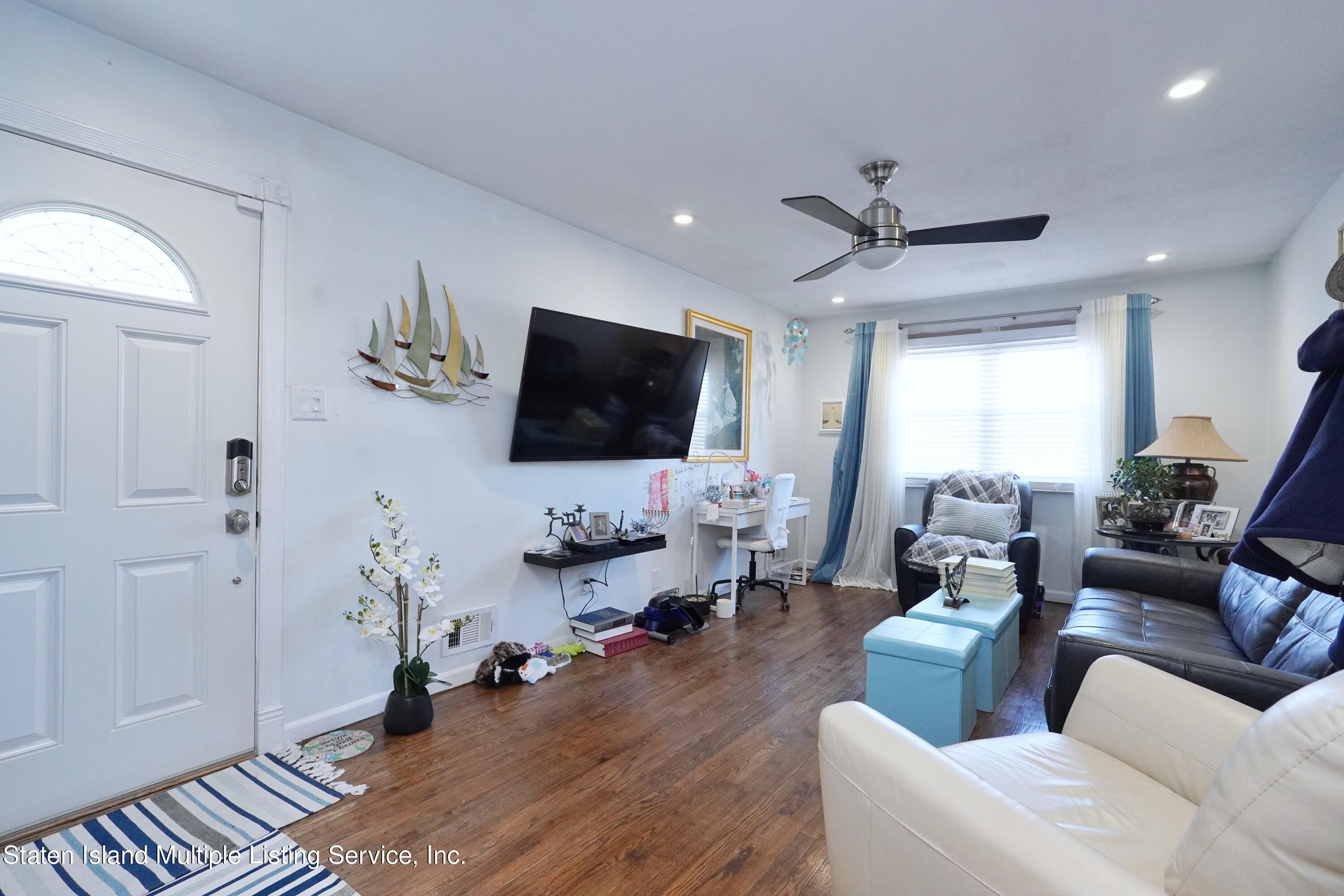 72 Middle Loop Road Staten Island, NY 10308 - Photo 4 of 38 a living room with furniture and a flat screen tv