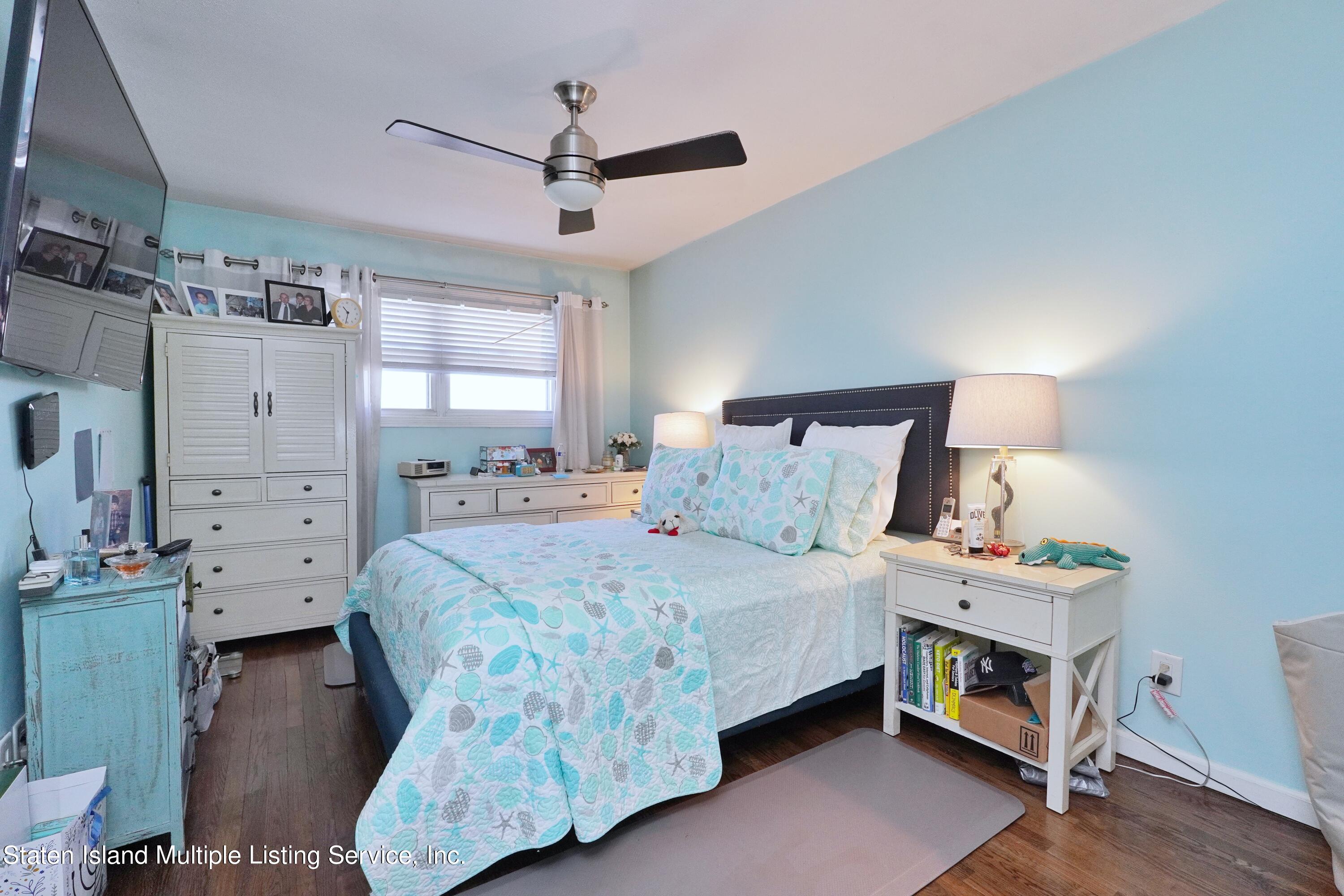 72 Middle Loop Road Staten Island, NY 10308 - Photo 6 of 38 a bedroom with a bed and a chandelier