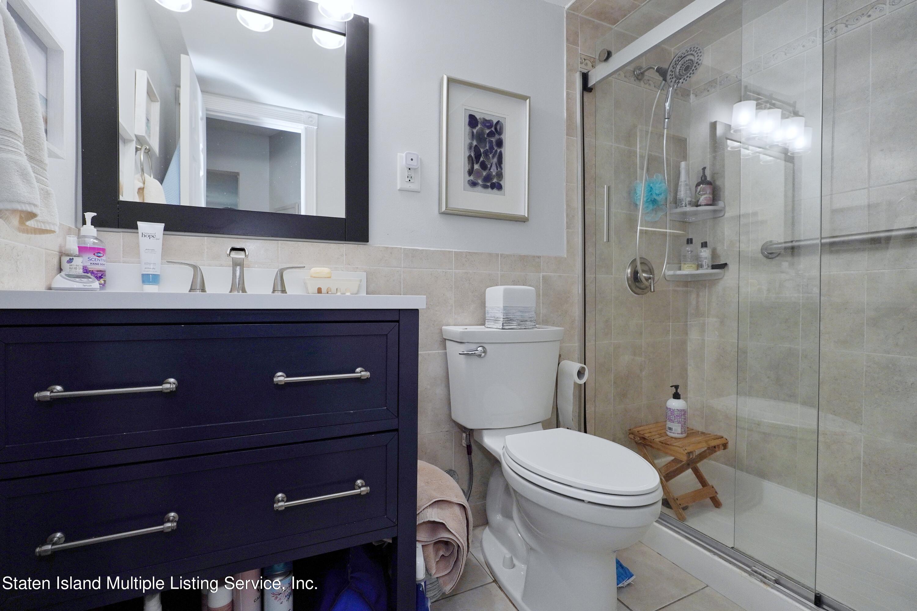 72 Middle Loop Road Staten Island, NY 10308 - Photo 8 of 38 a bathroom with a toilet a sink and mirror