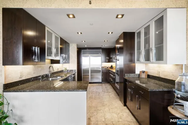 a kitchen with stainless steel appliances granite countertop a sink stove and refrigerator