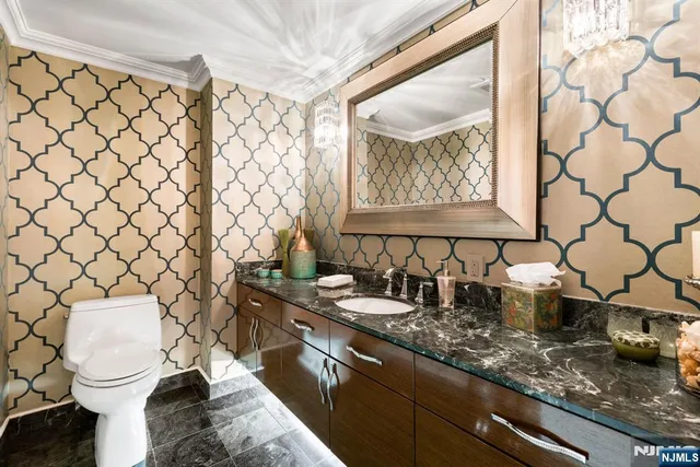 a bathroom with a granite countertop sink and a toilet
