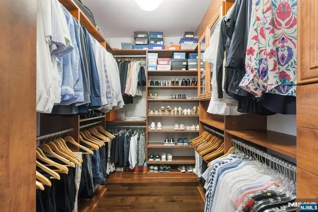 a view of walk in closet with clothes and shoes